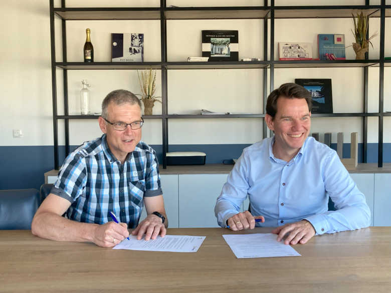 Voorzitter Paul Karrenbeld (links) en Andries Polman (rechts) aan tafel om het sponsorcontract te tekenen